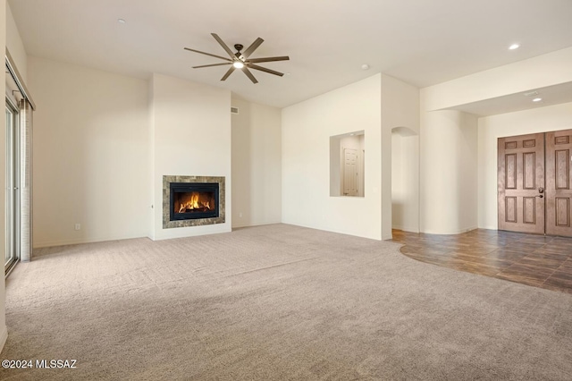 unfurnished living room with carpet and ceiling fan