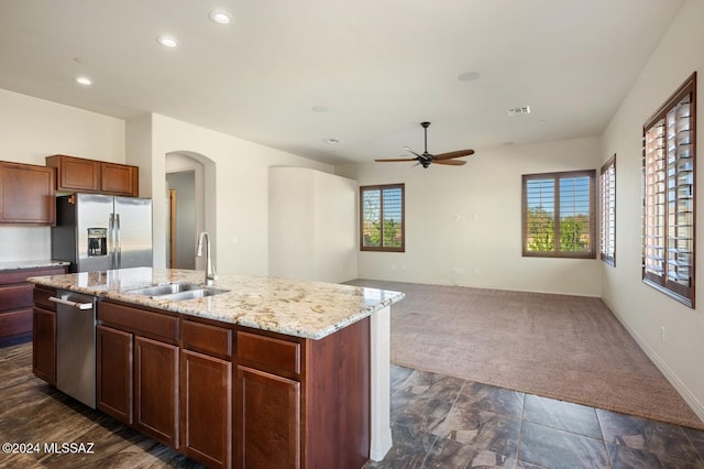 kitchen featuring dark colored carpet, a wealth of natural light, sink, and appliances with stainless steel finishes