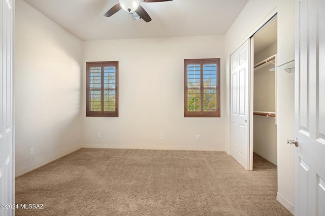 unfurnished bedroom with ceiling fan, a closet, and light carpet