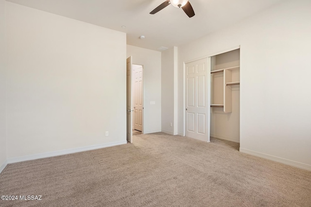 unfurnished bedroom featuring ceiling fan, light colored carpet, and a closet