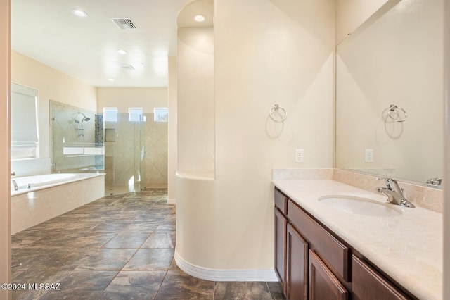 bathroom featuring vanity and independent shower and bath