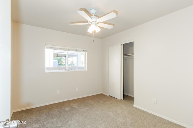 unfurnished bedroom with ceiling fan, light colored carpet, and a closet