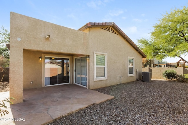 back of property with a patio and central AC