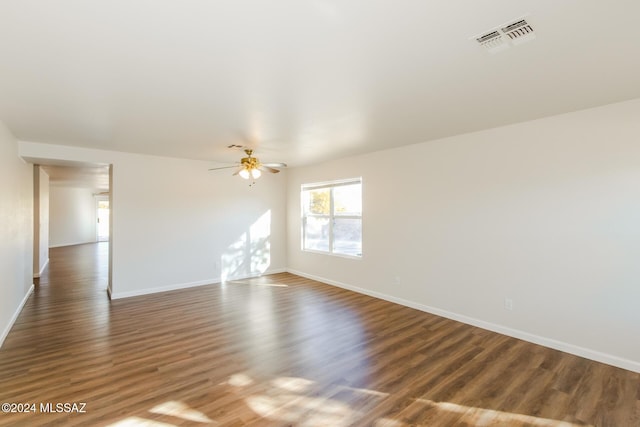 empty room with ceiling fan and dark wood-type flooring