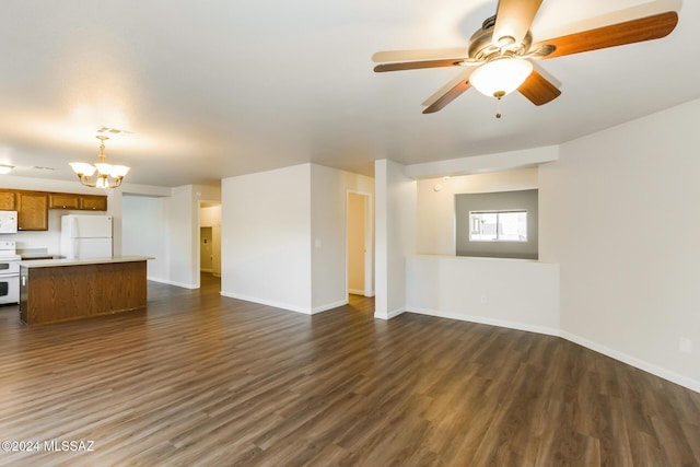 unfurnished living room featuring ceiling fan with notable chandelier and dark hardwood / wood-style floors