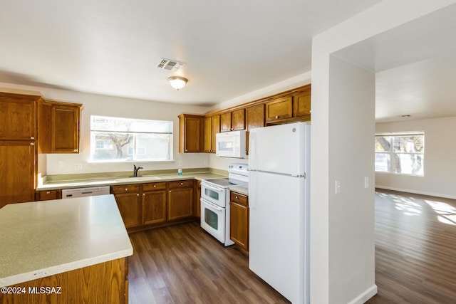 kitchen with dark hardwood / wood-style floors, white appliances, and sink