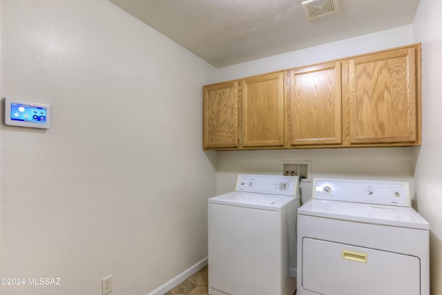 laundry area featuring independent washer and dryer, cabinets, and light tile patterned flooring