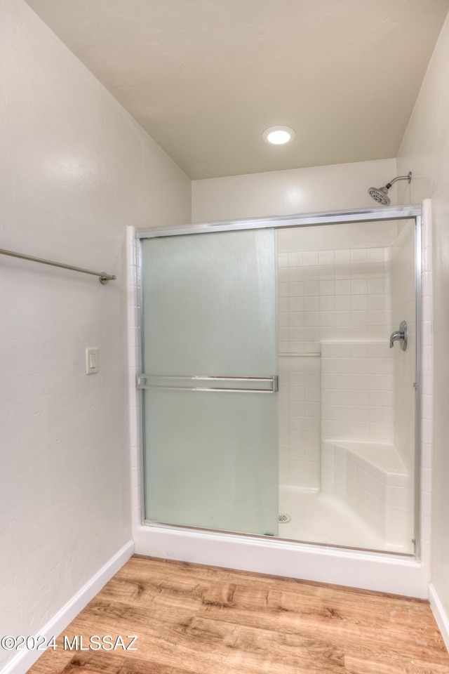 bathroom featuring hardwood / wood-style flooring and an enclosed shower