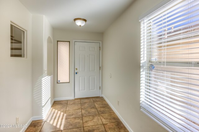 tiled spare room with ceiling fan and a wealth of natural light