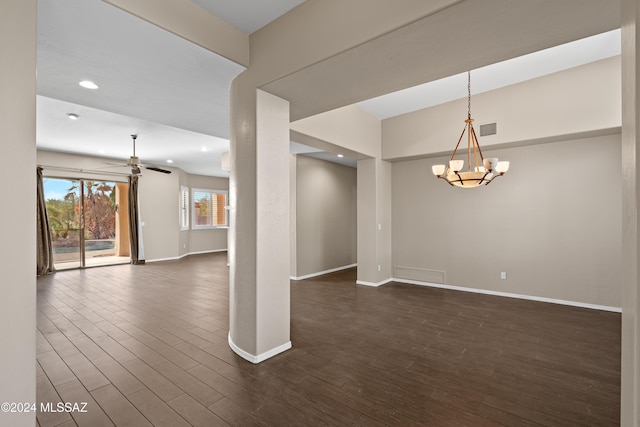 spare room with dark hardwood / wood-style flooring and ceiling fan with notable chandelier