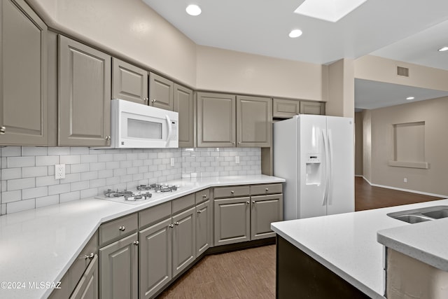 kitchen with white appliances, dark hardwood / wood-style floors, gray cabinets, and tasteful backsplash