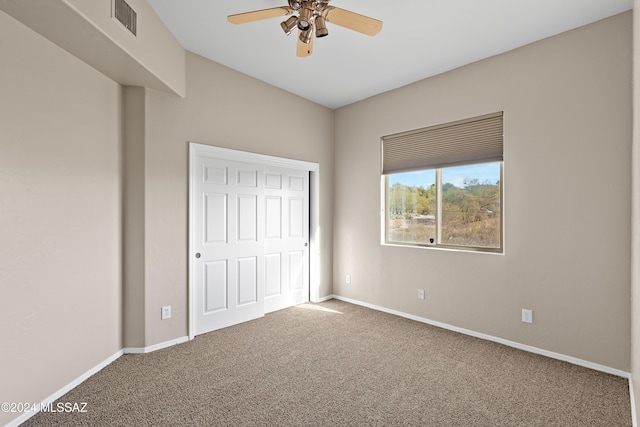 unfurnished bedroom featuring ceiling fan, a closet, and carpet floors