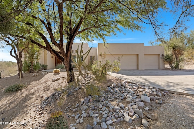 pueblo-style house featuring a garage