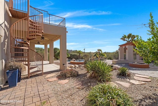 view of patio with ceiling fan and a balcony