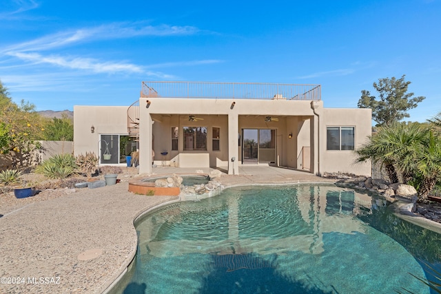 back of house featuring a balcony, ceiling fan, a patio area, and a pool with hot tub