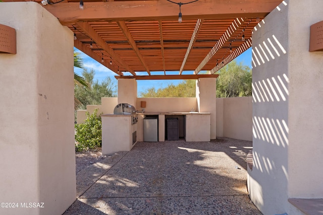 view of patio featuring a pergola, a grill, and exterior kitchen