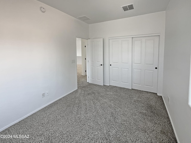 unfurnished bedroom featuring carpet flooring and a closet