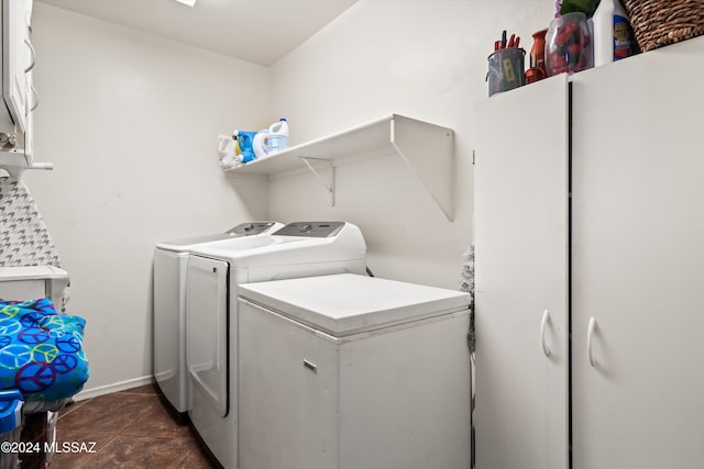 clothes washing area featuring separate washer and dryer and dark tile patterned flooring