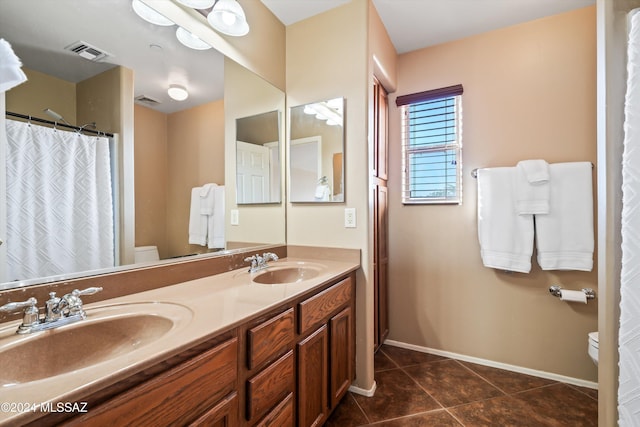 bathroom featuring tile patterned flooring, vanity, and toilet