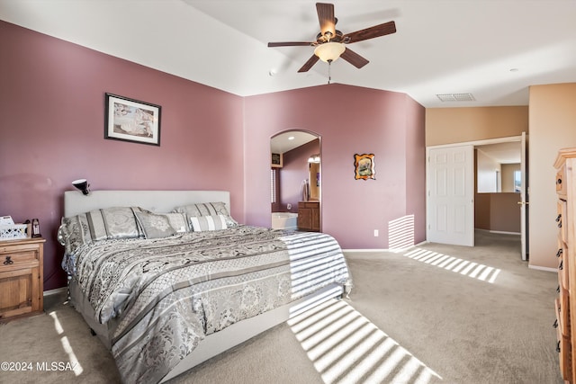 carpeted bedroom featuring ensuite bathroom, ceiling fan, and vaulted ceiling