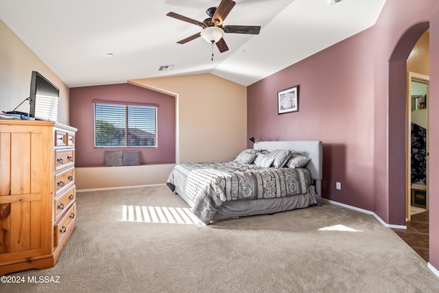 bedroom featuring dark colored carpet, vaulted ceiling, and ceiling fan