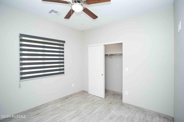 unfurnished bedroom featuring light hardwood / wood-style flooring, a closet, and ceiling fan