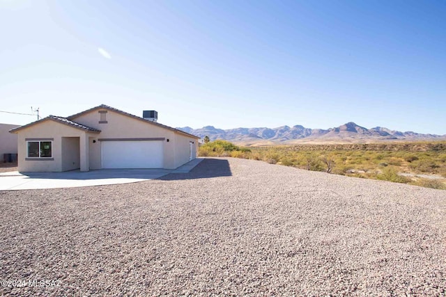 view of front of property featuring a mountain view, a garage, and cooling unit