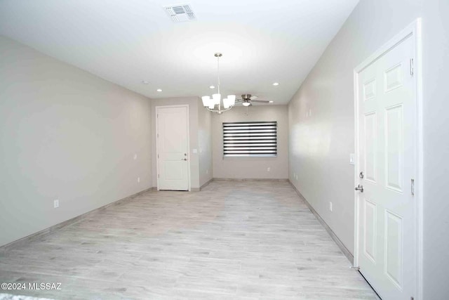 unfurnished dining area with ceiling fan with notable chandelier and light wood-type flooring