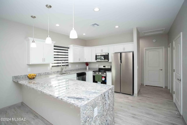 kitchen featuring stainless steel appliances, white cabinetry, hanging light fixtures, and sink