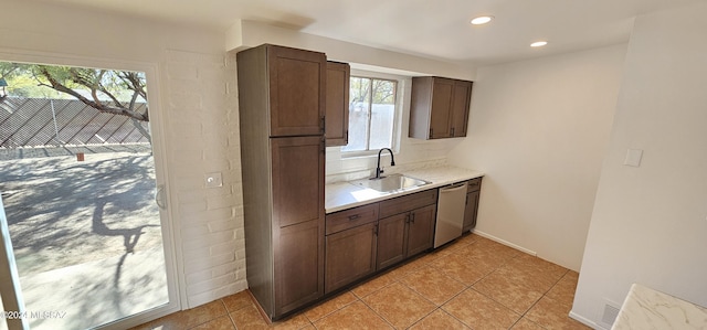 kitchen with dishwasher, dark brown cabinets, light tile patterned flooring, and sink