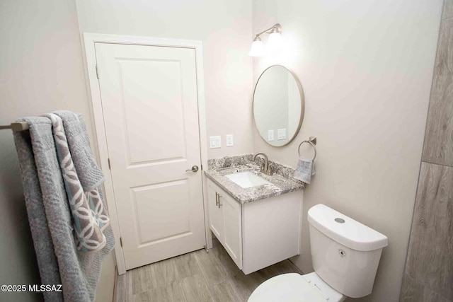 bathroom with vanity, hardwood / wood-style flooring, and toilet