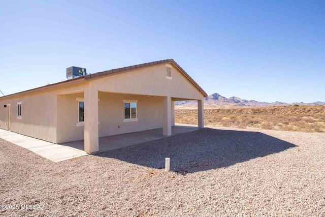 view of home's exterior featuring a mountain view and central AC unit