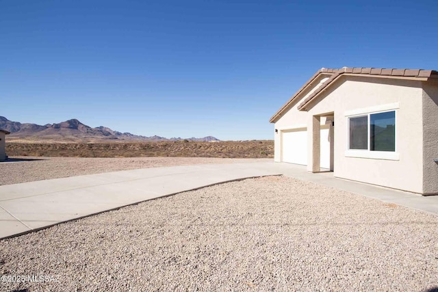 view of yard with a garage and a mountain view