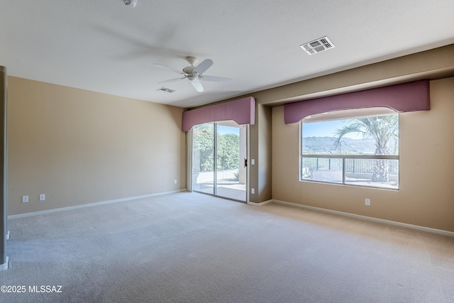unfurnished room with visible vents, ceiling fan, light carpet, and baseboards