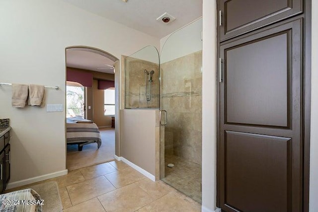 ensuite bathroom featuring ensuite bathroom, a stall shower, vanity, baseboards, and tile patterned floors