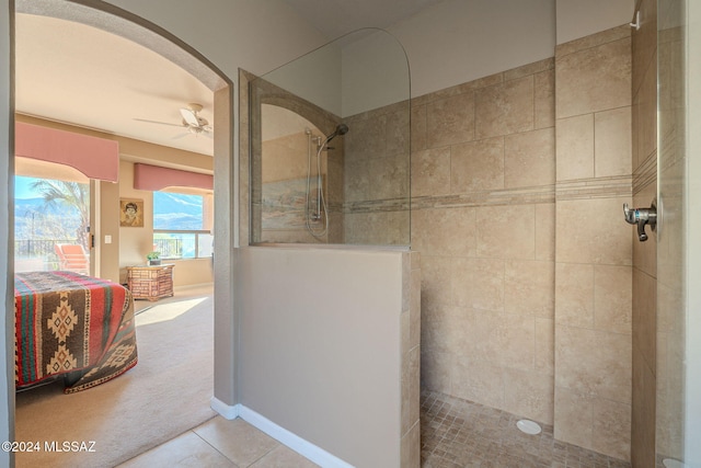 bathroom featuring ceiling fan, tile patterned flooring, connected bathroom, baseboards, and walk in shower
