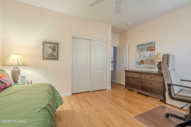 bedroom with a ceiling fan, a closet, baseboards, and wood finished floors