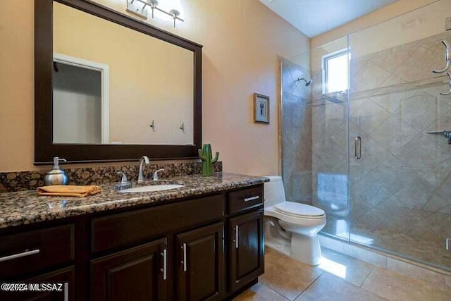 bathroom featuring tile patterned flooring, a shower stall, vanity, and toilet