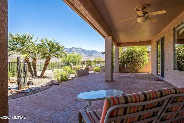 view of patio / terrace featuring a fenced backyard, a mountain view, and ceiling fan