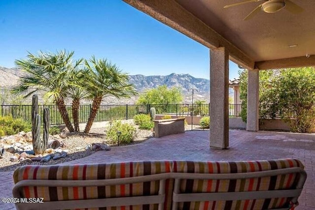 view of patio / terrace with ceiling fan, a fenced backyard, and a mountain view