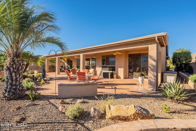 rear view of property featuring stucco siding, ceiling fan, and a patio