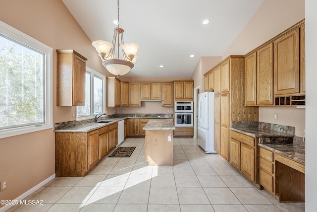 kitchen featuring white appliances, light tile patterned floors, lofted ceiling, a kitchen island, and a sink