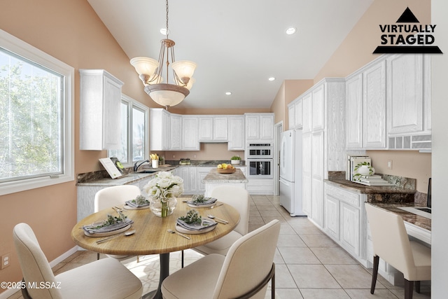 dining space featuring light tile patterned floors, vaulted ceiling, an inviting chandelier, and recessed lighting