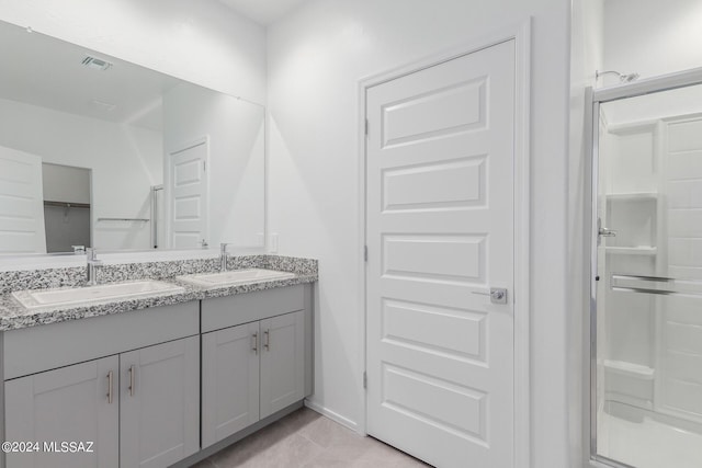 bathroom with tile patterned floors, vanity, and a shower with shower door