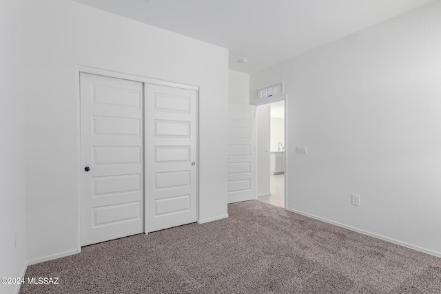 unfurnished bedroom featuring carpet flooring and a closet