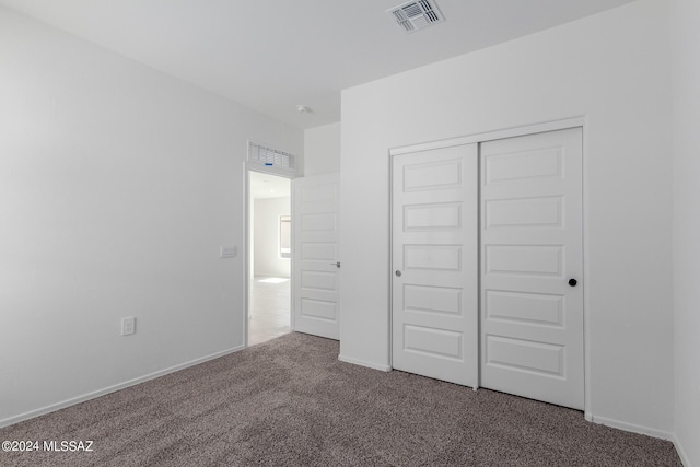 unfurnished bedroom featuring carpet flooring and a closet