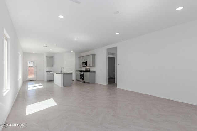 unfurnished living room with sink and light tile patterned floors