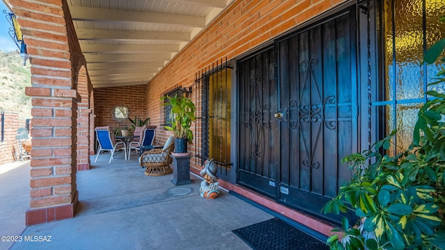 view of exterior entry featuring covered porch