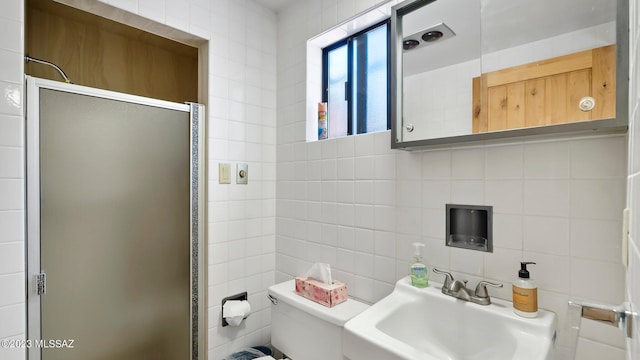 bathroom with sink, decorative backsplash, toilet, tile walls, and a shower with shower door