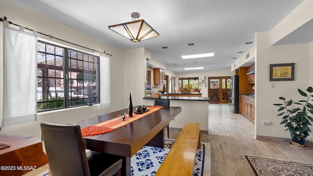 dining area featuring light wood-type flooring and a healthy amount of sunlight